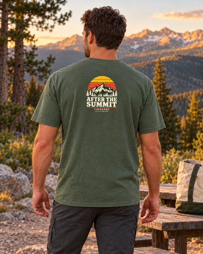 Man wearing the After the Summit Heavyweight Tee in Moss outdoors, showing the compact retro sunset and mountain back graphic.