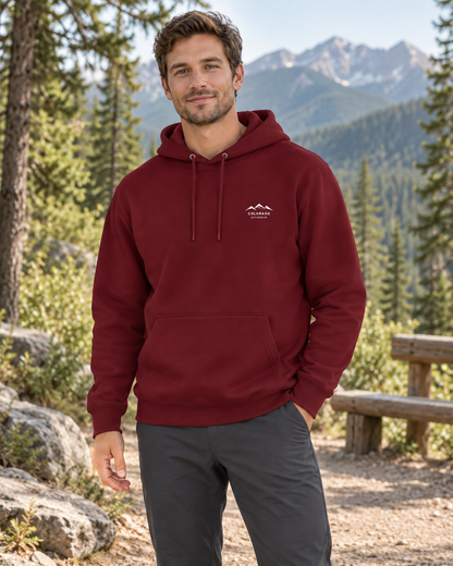 Man wearing the Alpine Social Club Fleece Hoodie in Burgundy outdoors, with a small white Colorado Activewear chest logo.