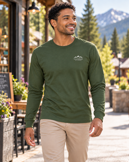 Man wearing the Alpine Social Club Jersey Long Sleeve in Military Green outside a mountain-town cafe, with a small white Colorado Activewear chest logo.