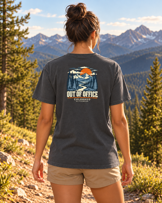 Woman wearing the Out of Office Heavyweight Tee in Pepper outdoors, showing the compact retro mountain and sunset back graphic.
